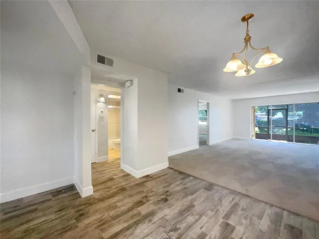 a view of a livingroom with a chandelier fan and a window