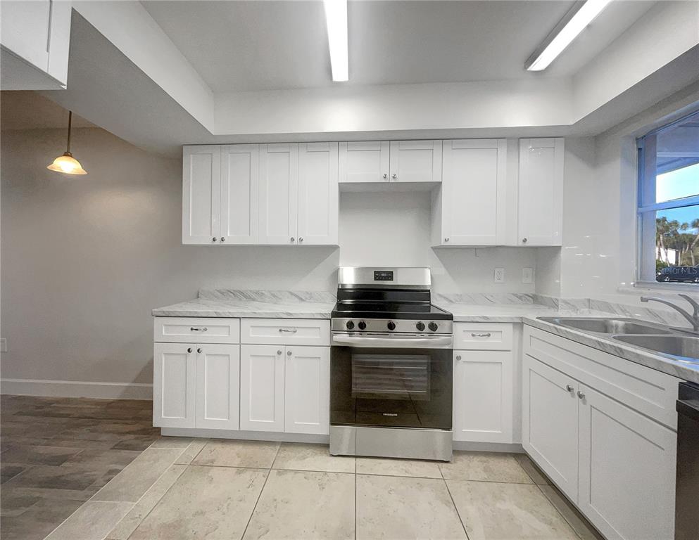 1028 Apollo Beach Boulevard, Unit 103 Apollo Beach, FL 33572 - Photo 6 of 22 a kitchen with a stove top oven and cabinets