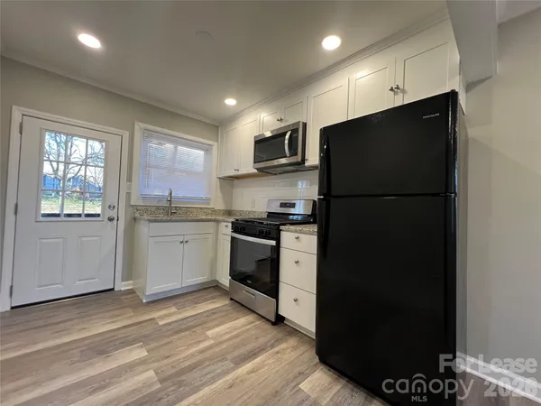 a kitchen with a refrigerator and a stove top oven