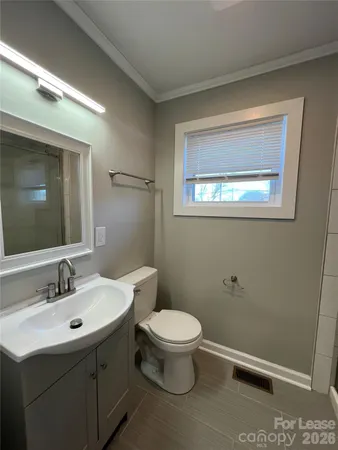 a bathroom with a toilet a sink and mirror