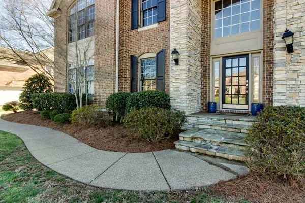 front view of a brick house with a yard