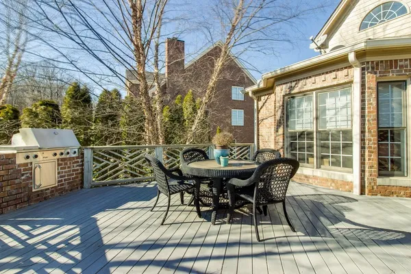 a view of a roof deck with table and chairs and wooden floor