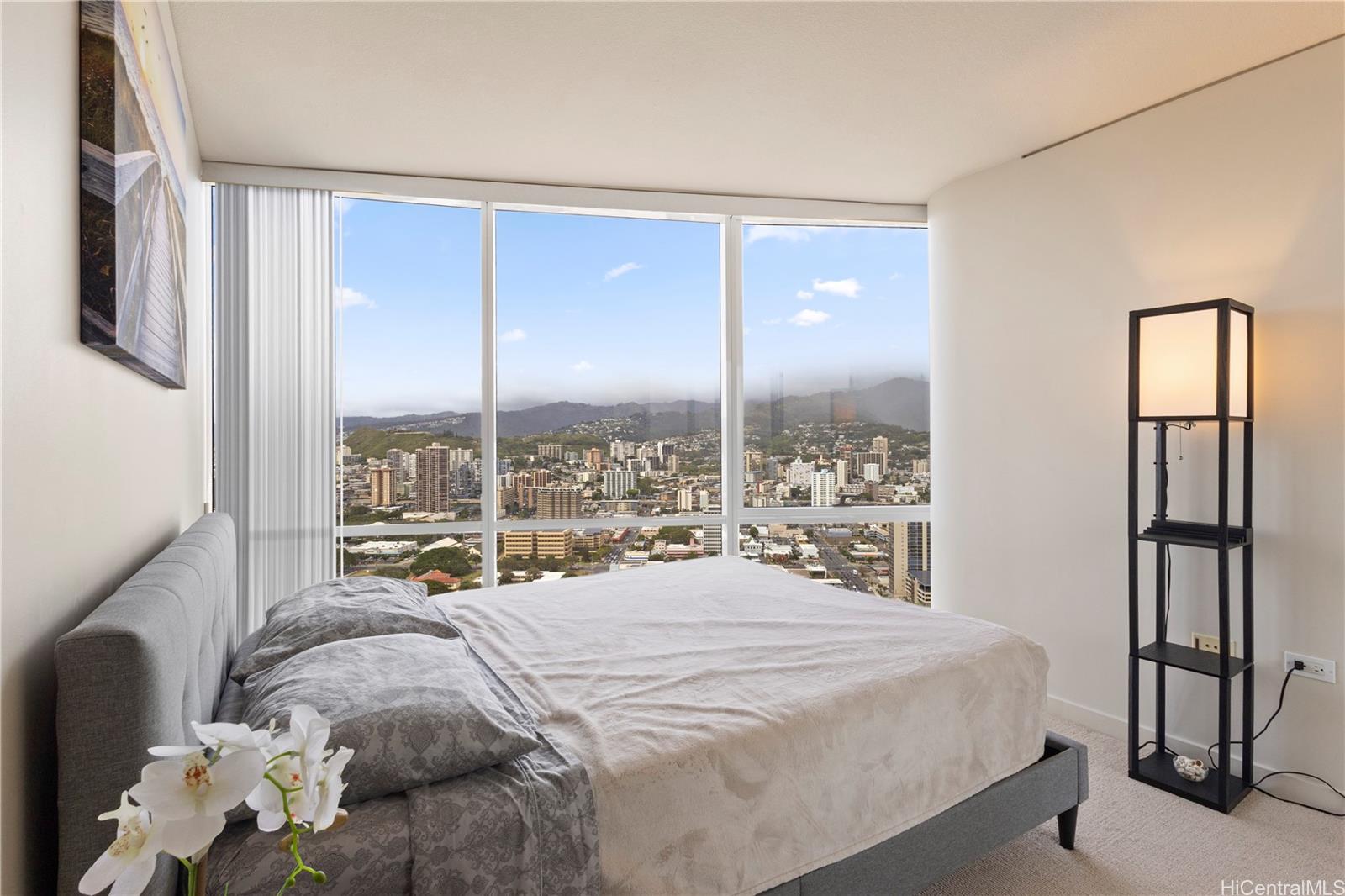 1288 Kapiolani Boulevard, Unit I4203 Honolulu, HI 96814 - Photo 13 of 25 a bed sitting in a bedroom next to a window