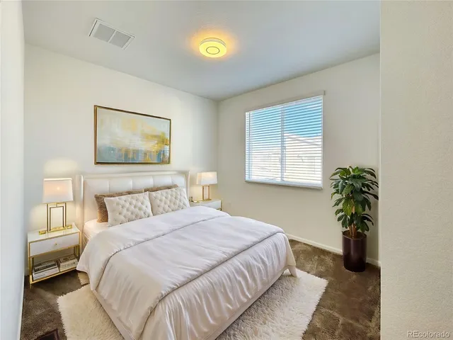 a bedroom with a bed and a potted plant