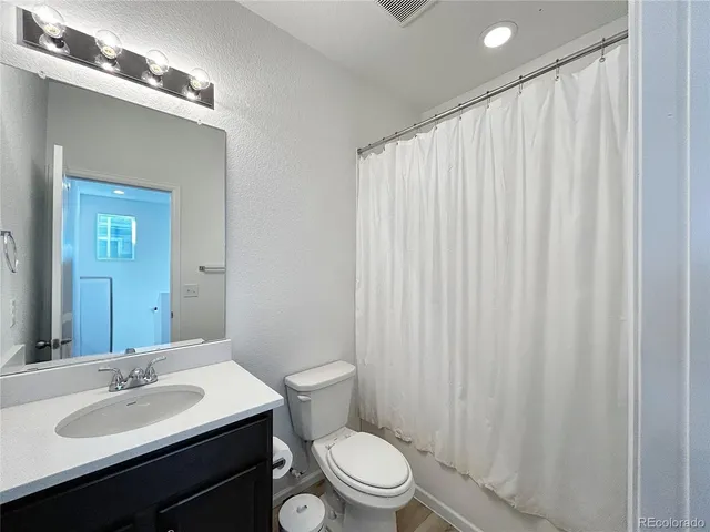 a bathroom with a toilet a sink and a mirror