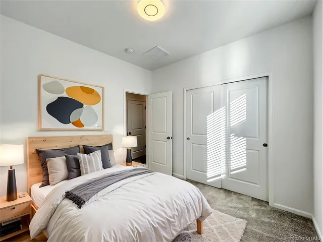 a bedroom with a bed and painting on the wall
