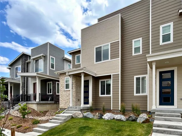 a front view of a house with yard and green space