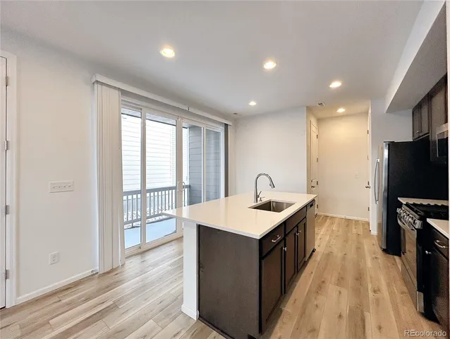 a kitchen with a sink a counter top space and stainless steel appliances