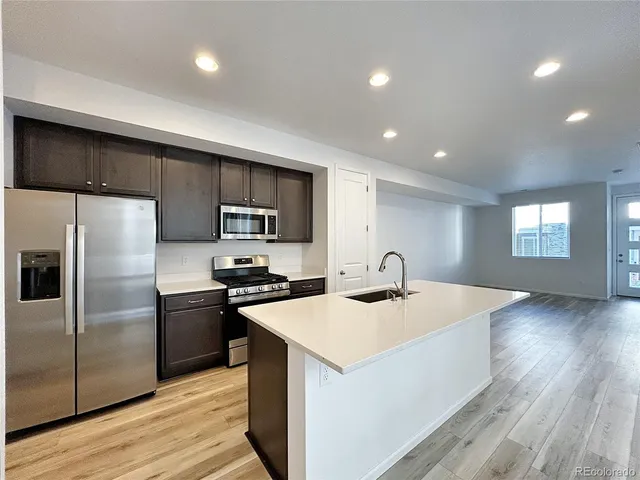 a kitchen with kitchen island a sink stainless steel appliances and counter space