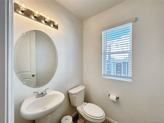 a bathroom with a toilet a sink and mirror
