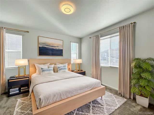 a bedroom with a bed and a potted plant