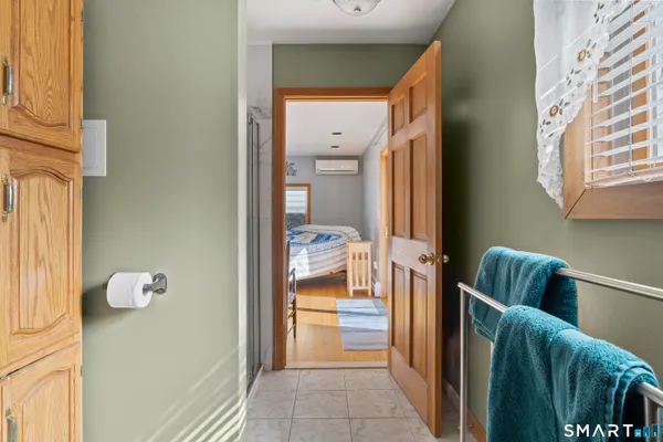 a bedroom with a bed and a dresser next to a window