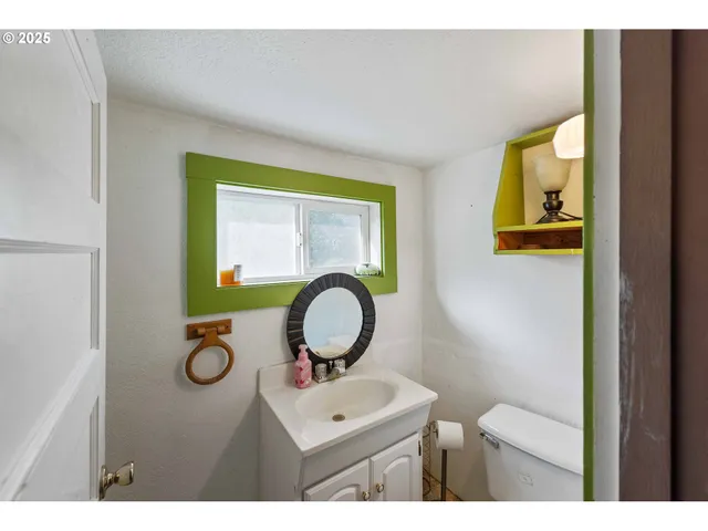 a bathroom with a toilet mirror vanity and sink