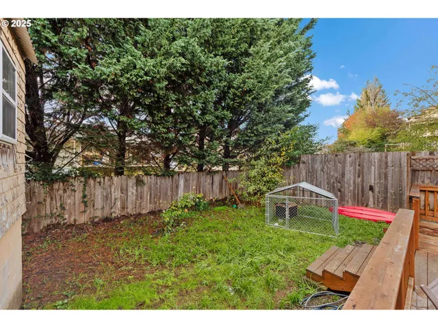 a view of yard with small cabin and wooden fence