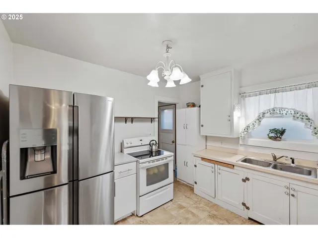 a kitchen with stainless steel appliances a refrigerator sink and cabinets