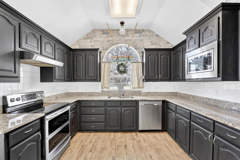 13616 Bates Aston Road Haslet, TX 76052 - Photo 19 of 36 a kitchen with stainless steel appliances granite countertop a sink and stove