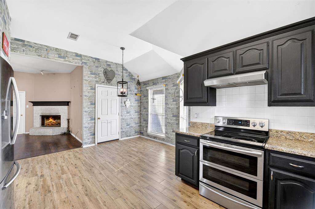 13616 Bates Aston Road Haslet, TX 76052 - Photo 21 of 36 a kitchen with granite countertop a stove cabinets and wooden floor