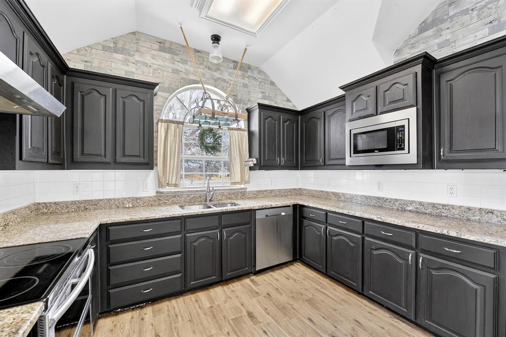13616 Bates Aston Road Haslet, TX 76052 - Photo 22 of 36 a kitchen with stainless steel appliances granite countertop a sink and cabinets