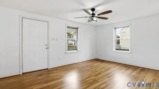 a view of a room with wooden floor and windows