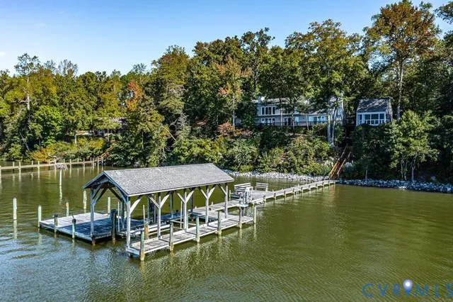 a view of a lake with a table and chairs under an umbrella