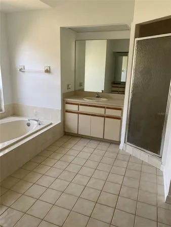 a spacious bathroom with a granite countertop sink a mirror and a bathtub
