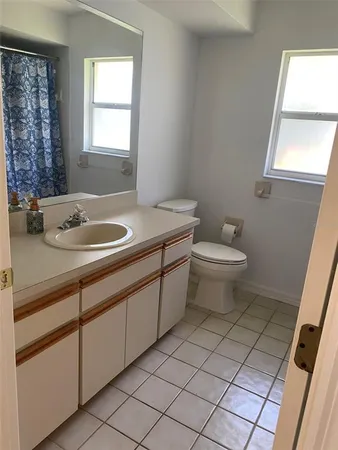 a bathroom with a sink toilet and window