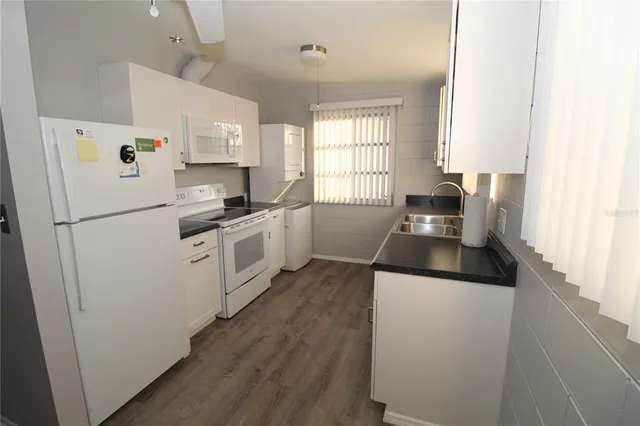 a white refrigerator freezer and a stove sitting inside of a kitchen