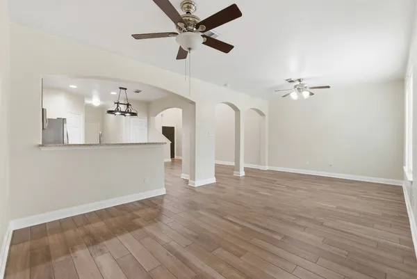 a view of a kitchen with wooden floor and a ceiling fan