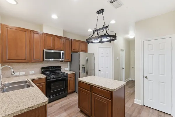a kitchen with stainless steel appliances granite countertop a sink stove and refrigerator