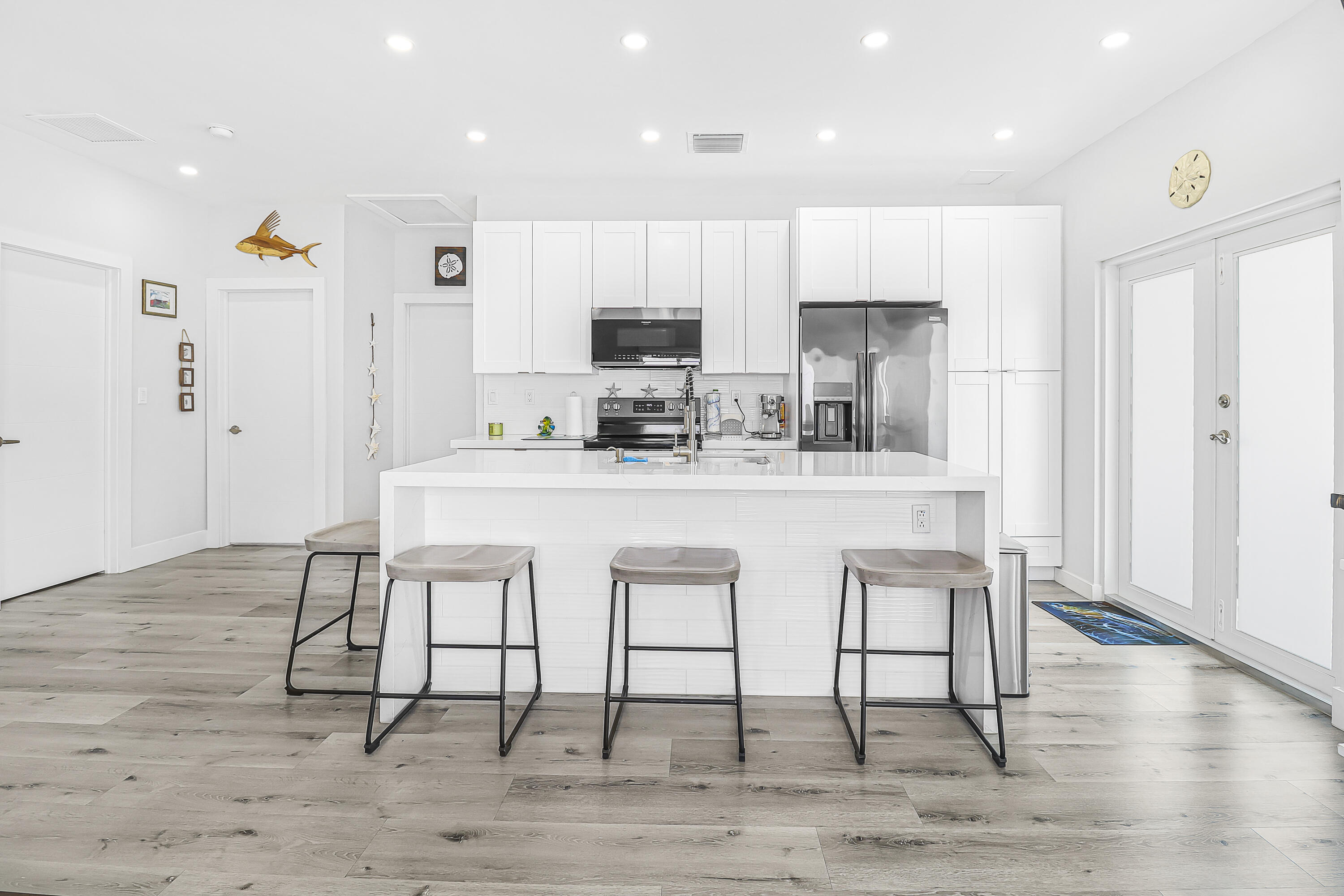 31575 Ave D Big Pine Key, FL 33043 - Photo 12 of 35 a kitchen with kitchen island granite countertop a dining table chairs cabinets and wooden floor