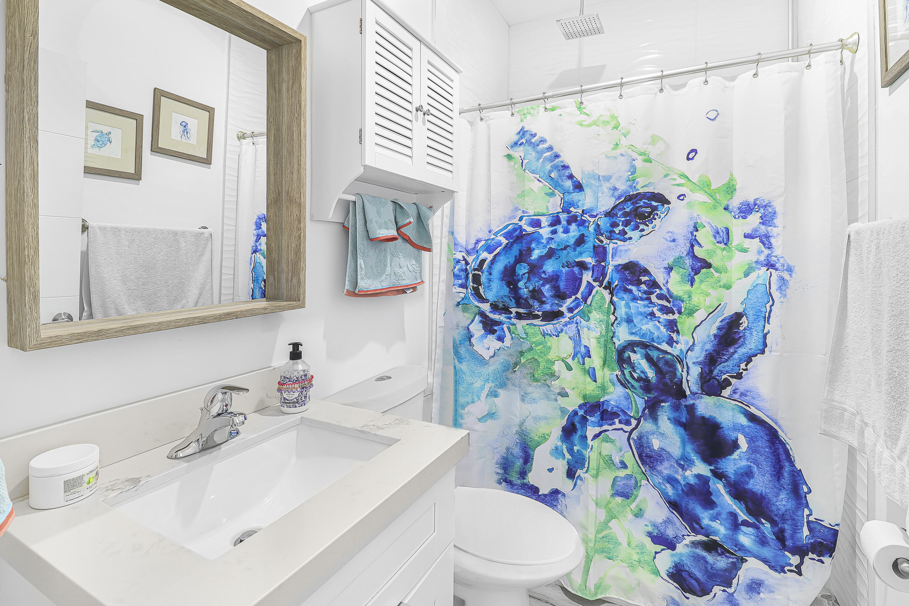 31575 Ave D Big Pine Key, FL 33043 - Photo 17 of 35 a bathroom with a sink mirror vanity and toilet