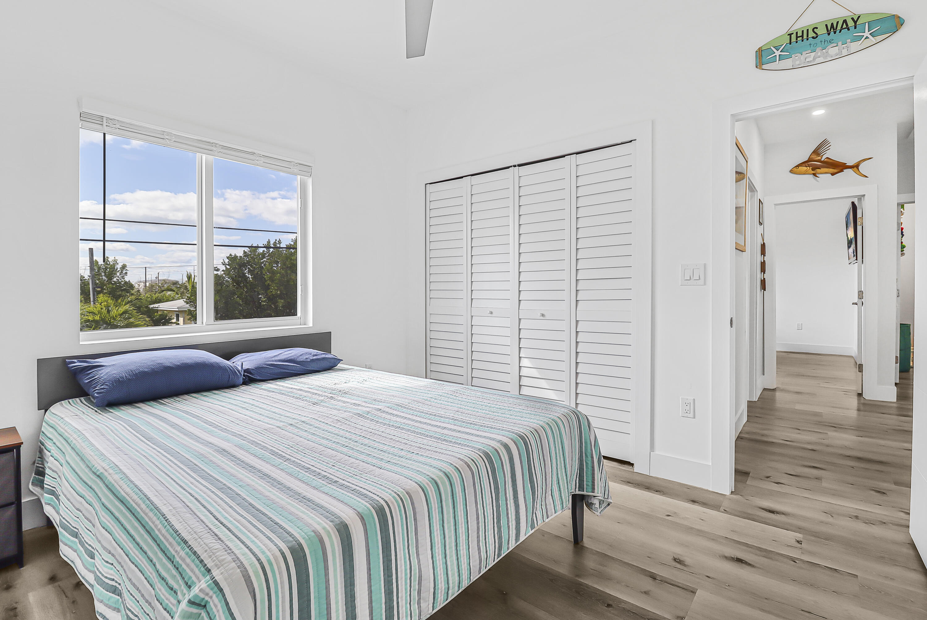 31575 Ave D Big Pine Key, FL 33043 - Photo 21 of 35 a bedroom with a bed and wooden floor