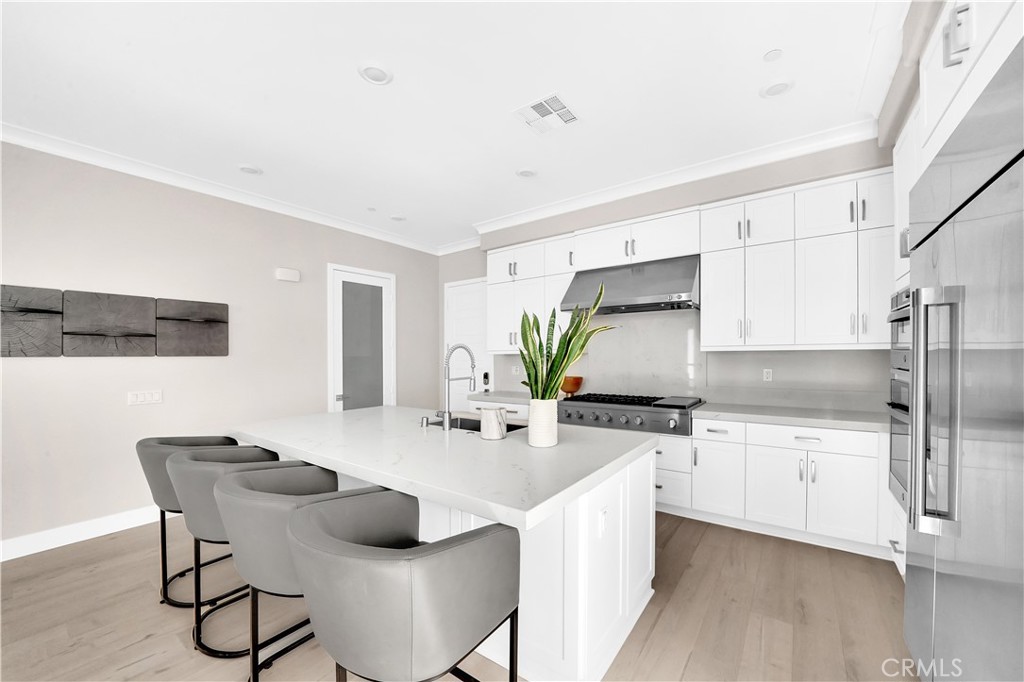 249 Chorus Irvine, CA 92618 - Photo 12 of 37 a kitchen with stainless steel appliances a sink a stove a table and chairs