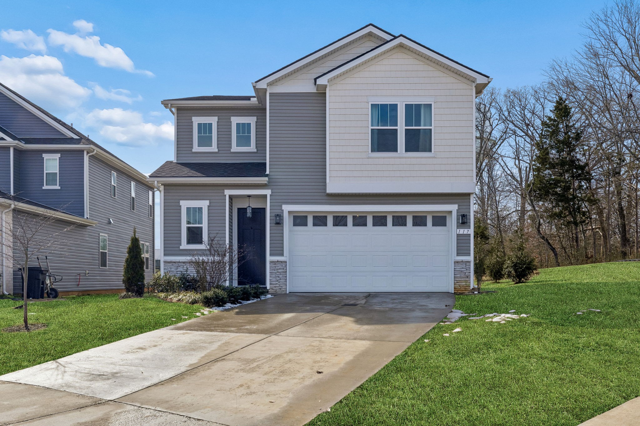 a front view of house with yard and garage
