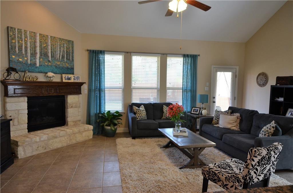 5629 Rio Chama Cove Austin, TX 78738 - Photo 4 of 34 A comforting living room offers a stone-faced fireplace, vaulted ceiling, and ample daylight.