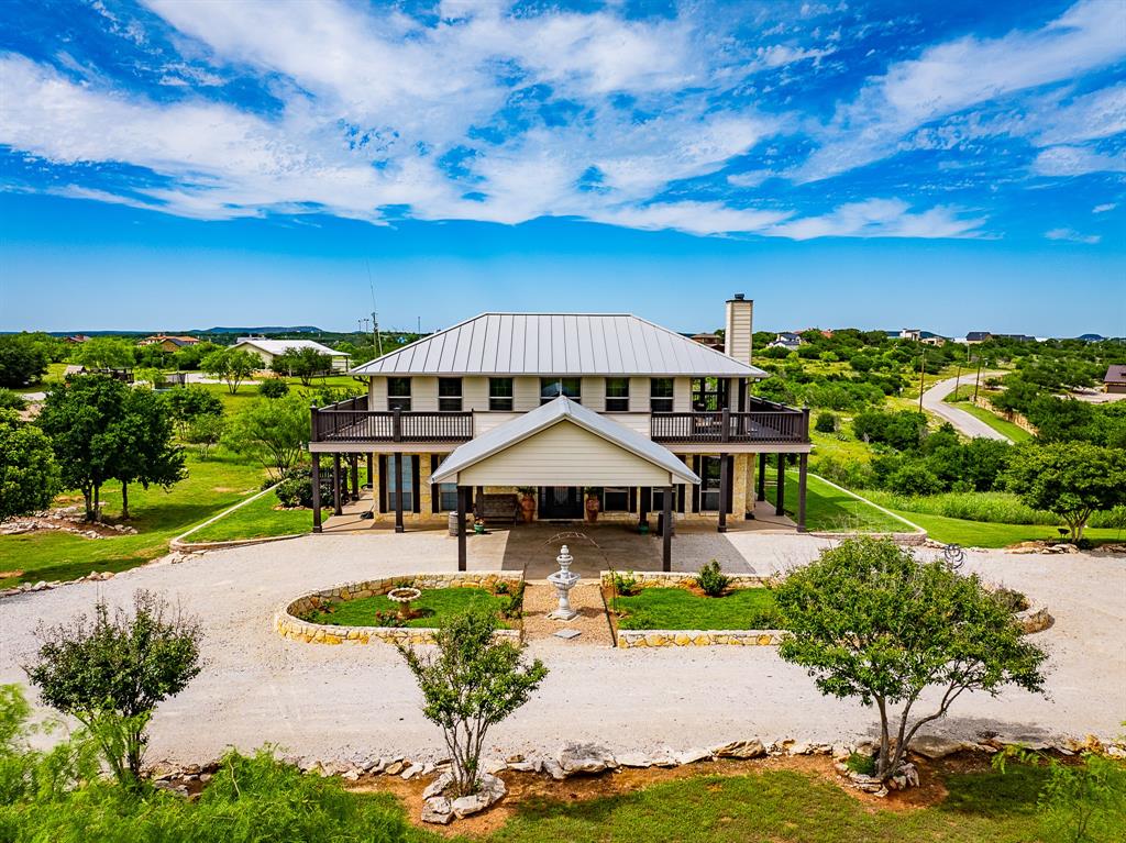 7060 Hells Gate Loop Strawn, TX 76475 - Photo 2 of 40 a view of a swimming pool with lawn chairs under an umbrella