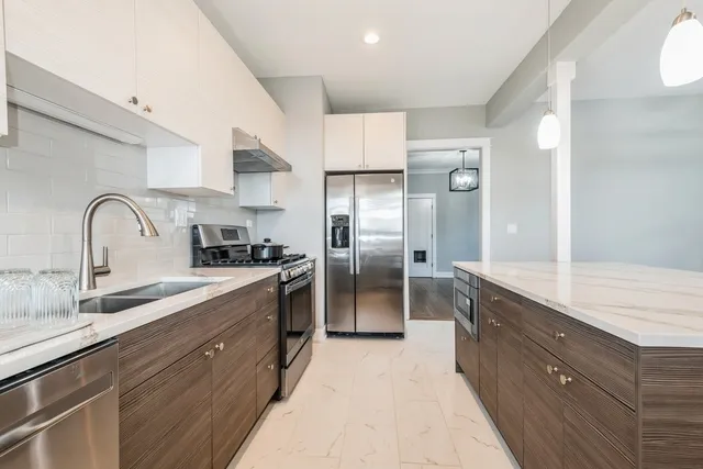 a kitchen with granite countertop a sink stainless steel appliances and cabinets