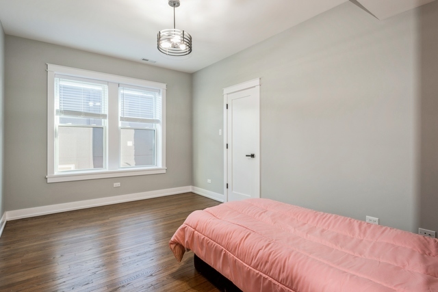 1535 West Estes Avenue, Unit 3 Chicago, IL 60626 - Photo 22 of 40 a bedroom with a bed and wooden floor