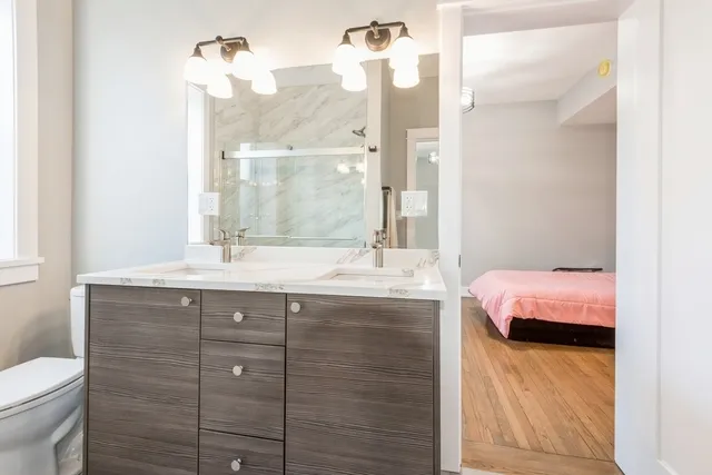 a bathroom with a granite countertop sink a toilet and shower