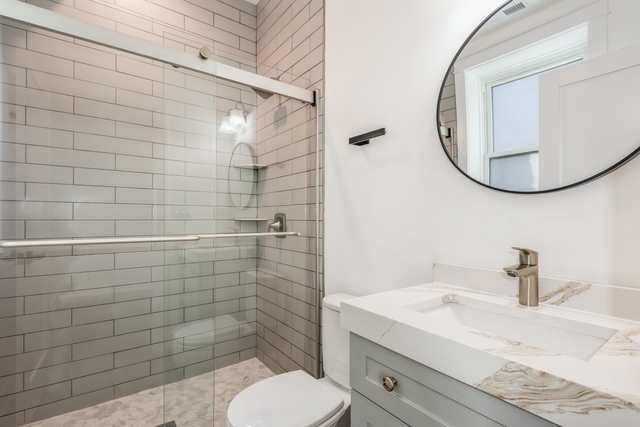 1535 West Estes Avenue, Unit 3 Chicago, IL 60626 - Photo 30 of 40 a bathroom with a toilet a sink and mirror