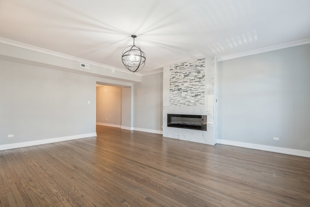 1535 West Estes Avenue, Unit 3 Chicago, IL 60626 - Photo 9 of 40 a view of an empty room with a window and wooden floor