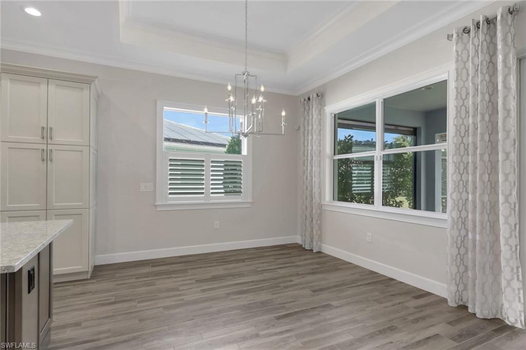 6482 Warwick Avenue Naples, FL 34113 - Photo 12 of 50 a view of an empty room with wooden floor and a window