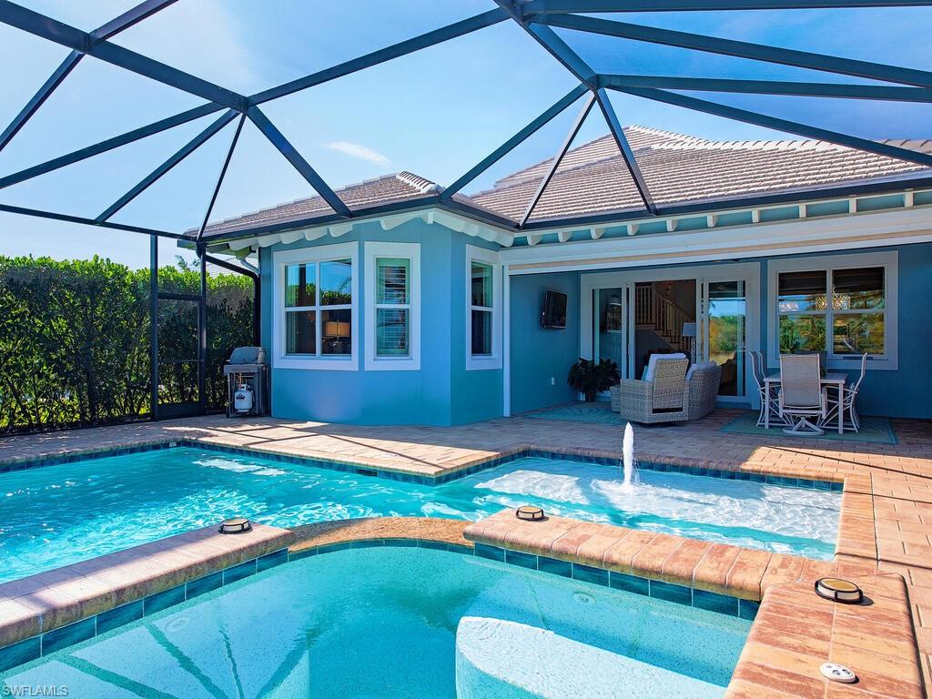 6482 Warwick Avenue Naples, FL 34113 - Photo 26 of 50 a patio with a table and chairs under an umbrella