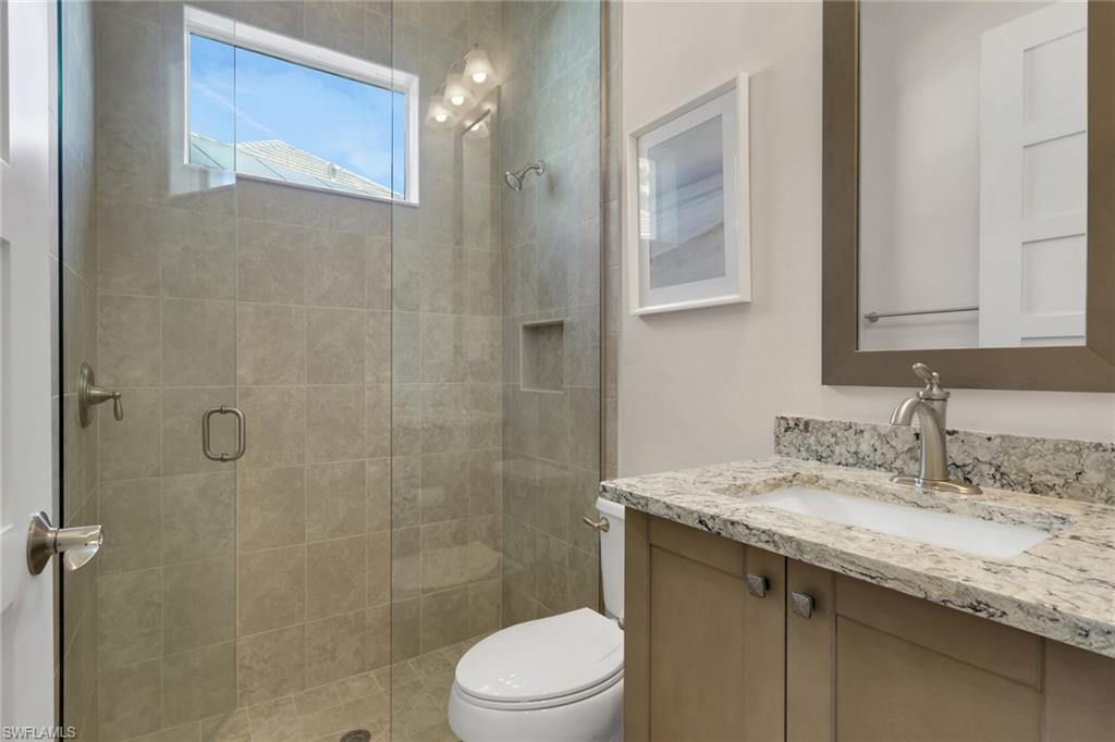 6482 Warwick Avenue Naples, FL 34113 - Photo 32 of 50 a bathroom with a granite countertop sink toilet and shower