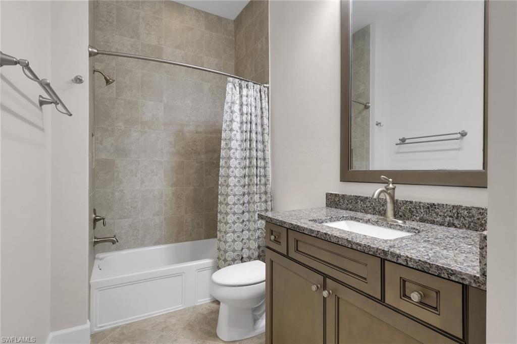 6482 Warwick Avenue Naples, FL 34113 - Photo 37 of 50 a bathroom with a granite countertop sink a toilet and bathtub