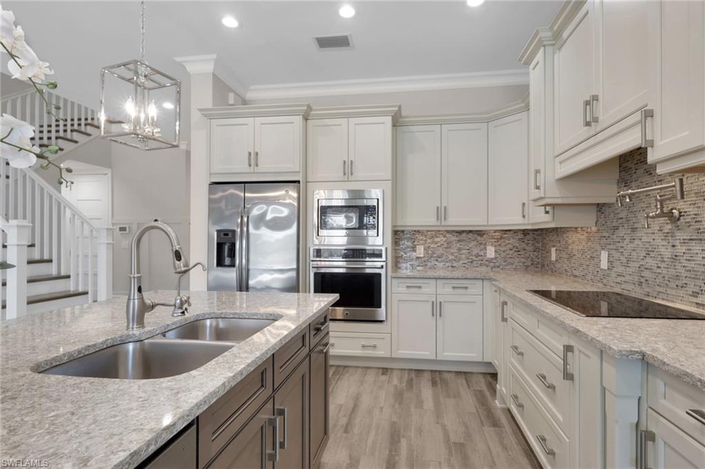 6482 Warwick Avenue Naples, FL 34113 - Photo 10 of 50 a kitchen with cabinets stainless steel appliances a sink and a stove