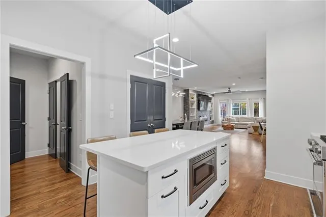 a kitchen with a stove a refrigerator and a wooden floor