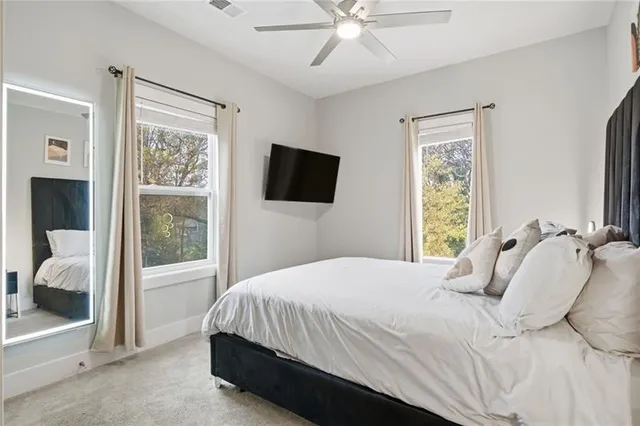 a bedroom with a bed and a flat tv screen on dresser