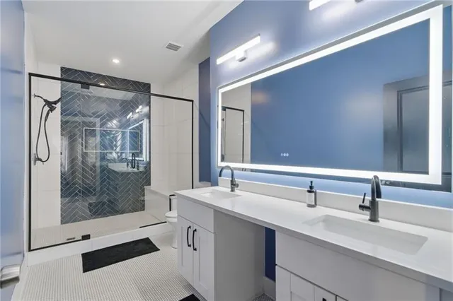a bathroom with a double vanity sink mirror and shower