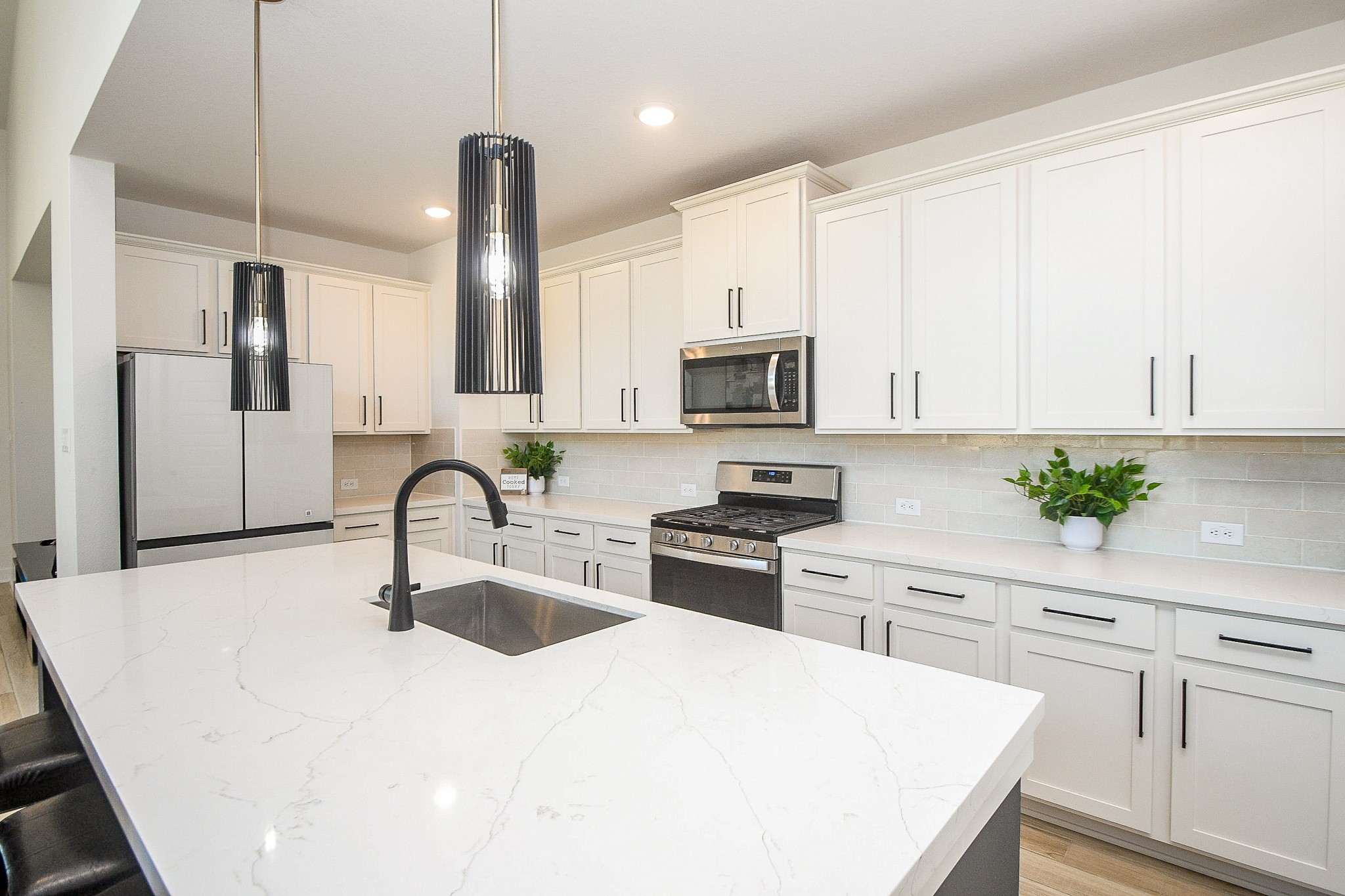 31407 Splitting Willow Lane Fulshear, TX 77441 - Photo 11 of 19 a kitchen with white cabinets a sink stove and refrigerator